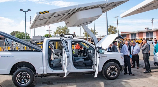 Electric pickup truck being charged at solar charging station