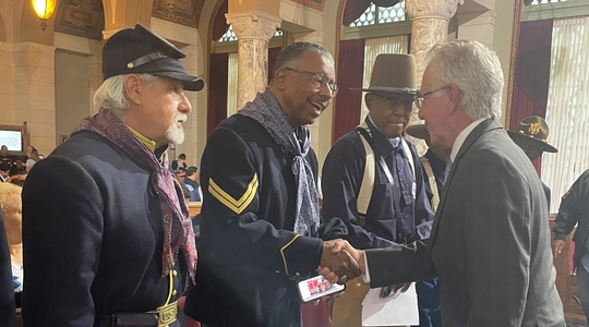 CP Krekorian shakes hands with men in 19th century cavalry uniforms