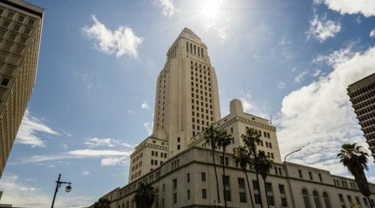 Exterior view of City Hall with the sun glaring at the pinnacle
