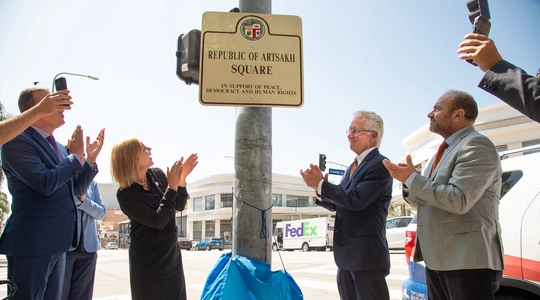 Councilmemer traci park, Coulncil president kreorian and former State Assemblymember Adrin Nazarian applaud as Artsakh Square sign is unveiled.