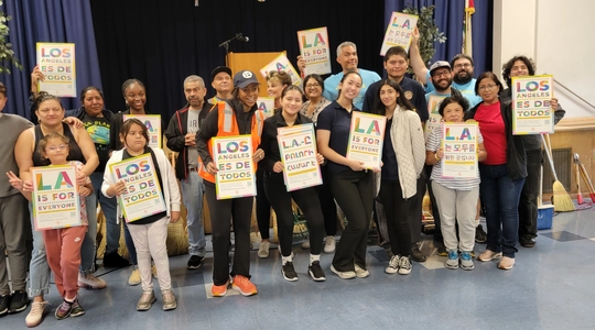 Young volunteers hold LA For All signs.