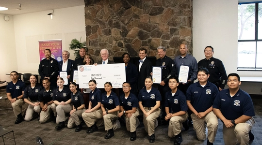 Council President presents oversized check to class of students