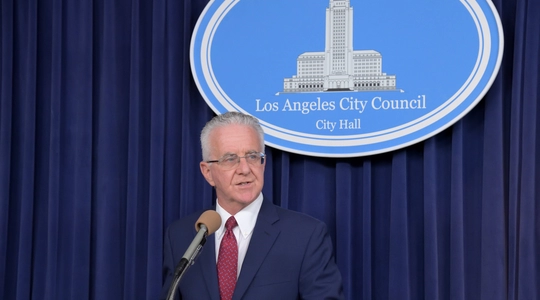 Council President Krekorian at lectern in City Hall media room during press conference on homeless man abandoned by Burbank police in front of his Council office.