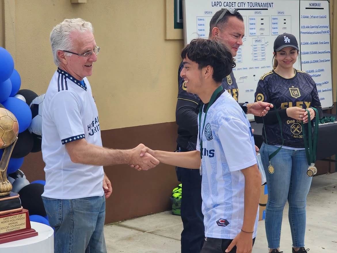Council President Krekorian shakes hands with young soccer player.