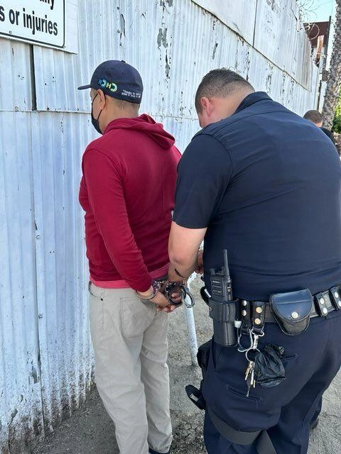 A photo of a copper wire thief being handcuffed.