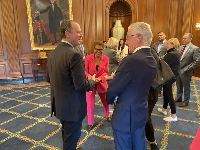 Representative Adam Schiff talks with Council President Krekorian as Mayor Bass looks on, smiling.