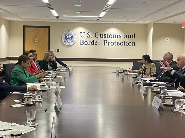 Councilmembers seated at long conference table under sign that reads 'U.S Customs and Border Protection"