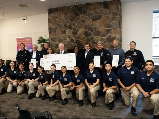 Council President presents oversized check to class of students