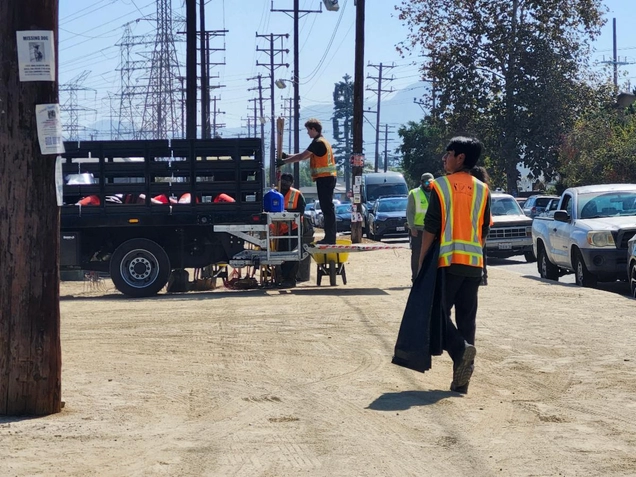 A volunteer takes a bag of trash to the truck.