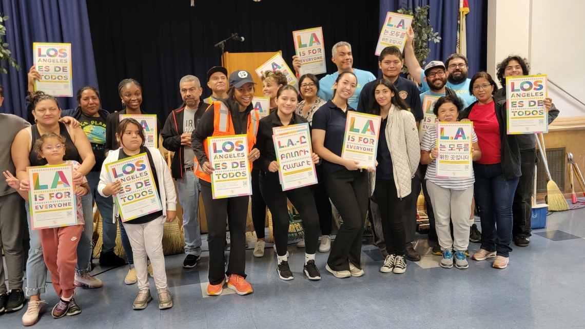 Young volunteers hold LA For All signs. 