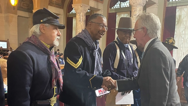 CP Krekorian shakes hands with men in 19th century cavalry uniforms